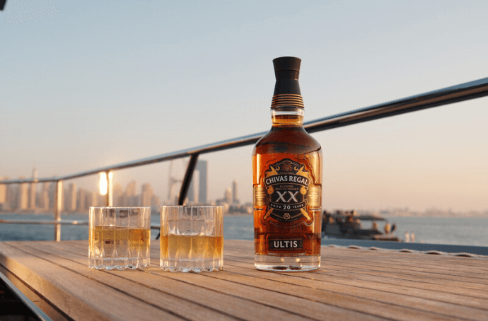 Butelka Chivas Regal Ultis obok dwóch szklanek